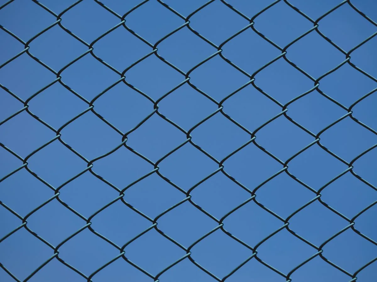 Clean chain link fence against a blue sky