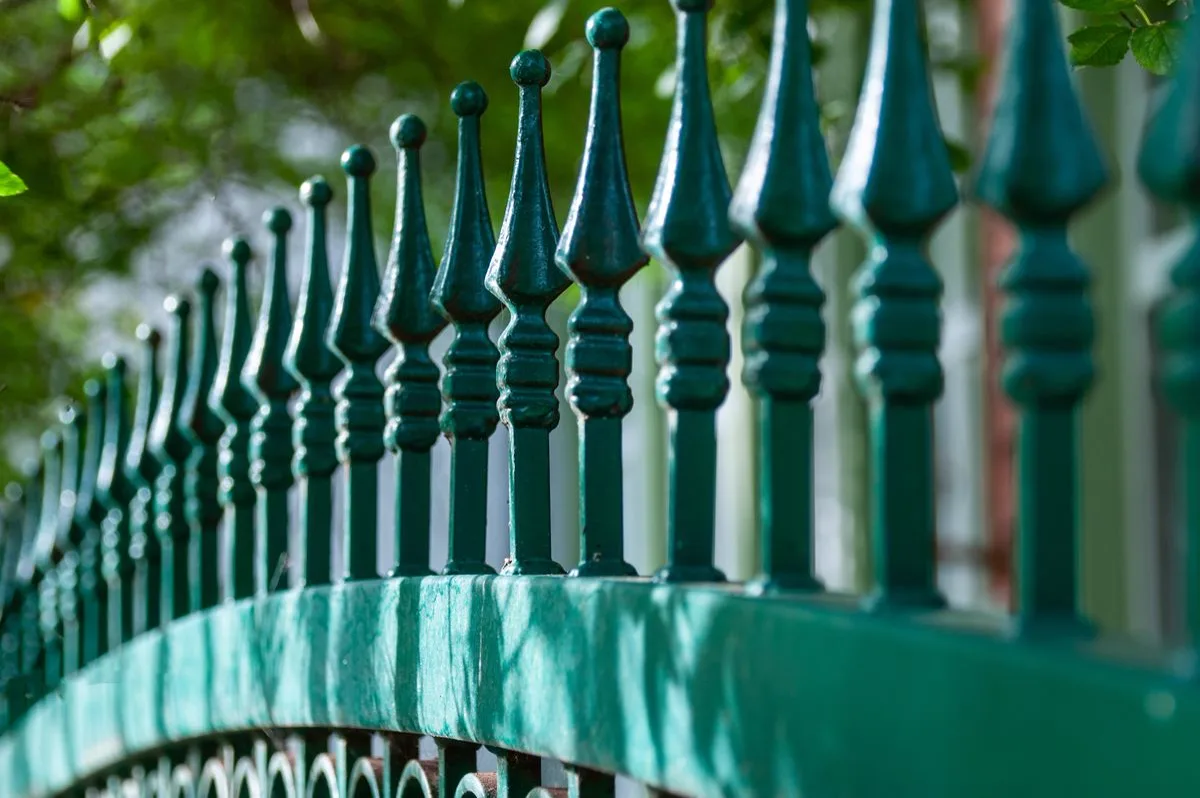 Ornamental iron fence finials in afternoon light