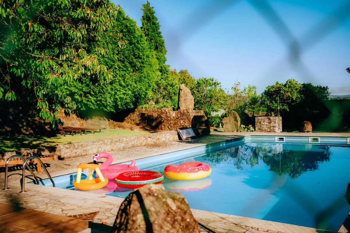 Backyard swimming pool seen through a safety fence
